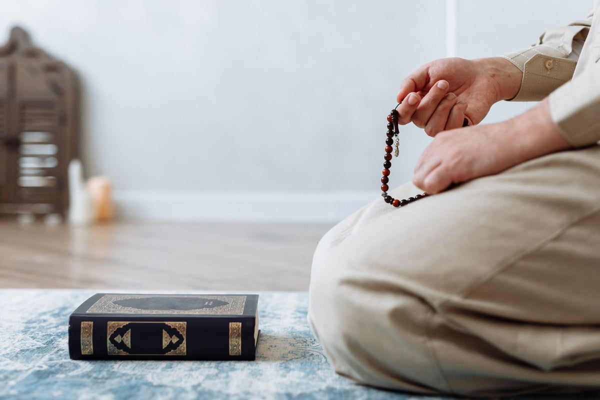 Perles de prière posées près de pages ouvertes, lumière claire
